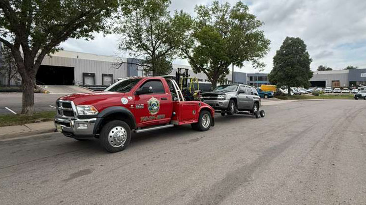 Interceptor Towing red wrecker hauling an SUV through a Denver, Colorado property